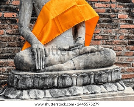a photography of a statue of a person sitting on a stone base.