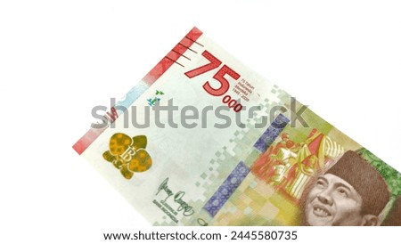 Indonesian banknotes in the denomination of 75,000 rupiah. Limited edition to commemorate the 75th anniversary of the independence of the Republic of Indonesia. Isolated on white background