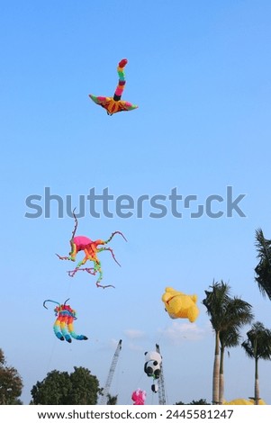 Colorful kites flying in the clear blue sky in sunny summer day at Mekong Delta Vietnam. Happy childhood moments.