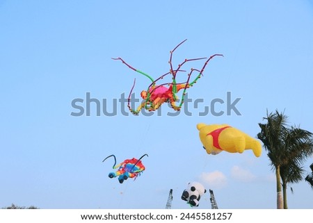 Colorful kites flying in the clear blue sky in sunny summer day at Mekong Delta Vietnam. Happy childhood moments.