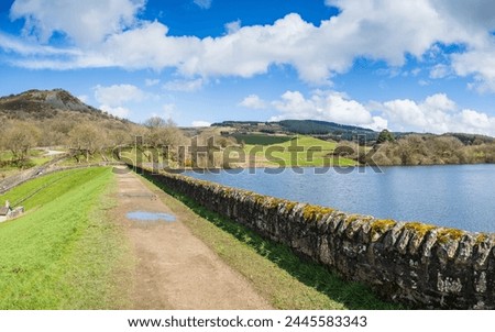 Path and stone wall surround Bottoms Reservoir pictured under Tegg's Nose Country Park in March 2024.