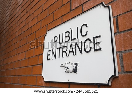 Close up of a public entrance sign on a brick wall seen in Derbyshire.
