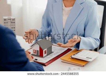 A real estate agent talks with his client regarding a home purchase contract, concept for real estate, moving house or renting property.