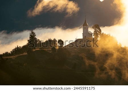 Jamnik, Slovenia. The Jamnik Church is a charming 15th-century chapel in the Kamnik-Savinja Alps near Kranj, breathtaking views of the surrounding mountainous landscape. Royalty-Free Stock Photo #2445591175