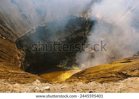 Bromo active volcano crater with smoke and yellow sulfur