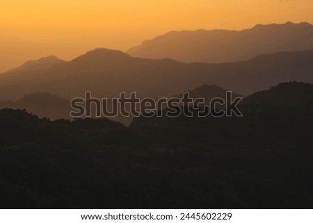nature traveling with orange sky and layer of mountain with sunrise background