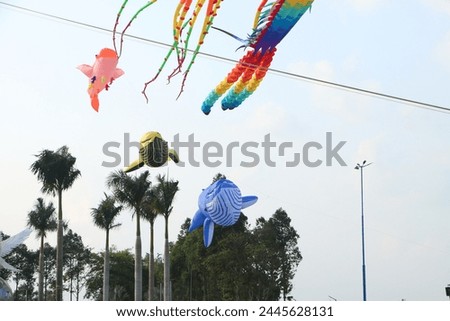 Can Tho, Vietnam - March 23, 2024: Colorful balloon fishes kites flying in the blue sky in sunny summer day at Vietnam.