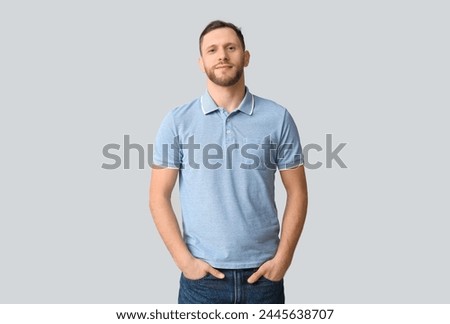 Man in stylish polo shirt on light background