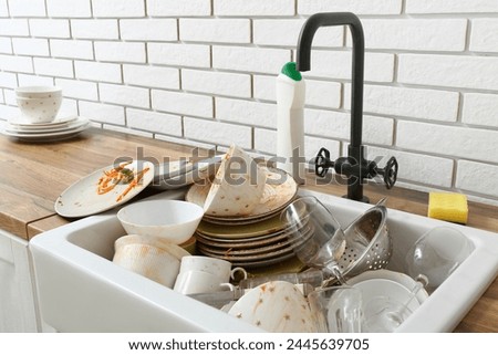 Sink with dirty dishes in kitchen