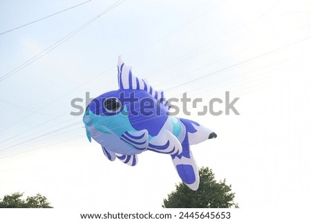 Colorful balloon fish kite flying in the blue sky in sunny summer day at Vietnam.