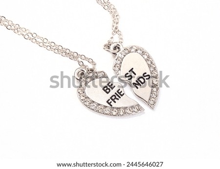 Broken heart best friend necklace, in silver on white background and copy space Royalty-Free Stock Photo #2445646027