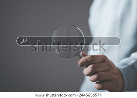 hand holding magnifying glass. Searching for information. Using Search Console with your website. Data Search Technology Search Engine Optimization. Online business search a job for work	
