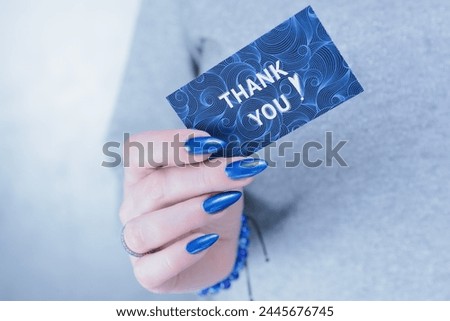 Female hands hold a picture with the inscription Thank you