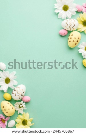 Easter whimsy: a playful array of eggs and blooms. Top view vertical photo of decorative eggs, white ceramic bunny, assortment of spring flowers on teal background with space for greeting text