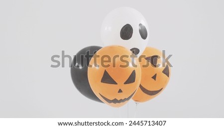 Image of happy halloween text over neon witch and orange and black balloons. halloween tradition and celebration concept digitally generated image.