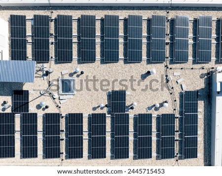Aerial top down view of new building project with solar panels mounted on the roof using photo-voltaic cells which use sunlight as a source of energy (4K).