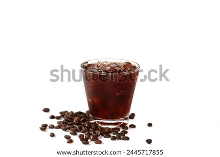 Americano ice coffee and coffee beans spreading around glass with isolated picture.