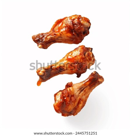 Roasted chicken wings with spices and herbs, flying isolated on white background. floating BBQ chicken drumsticks with vegetables isolated on white background. fried chicken wings. Royalty-Free Stock Photo #2445751251