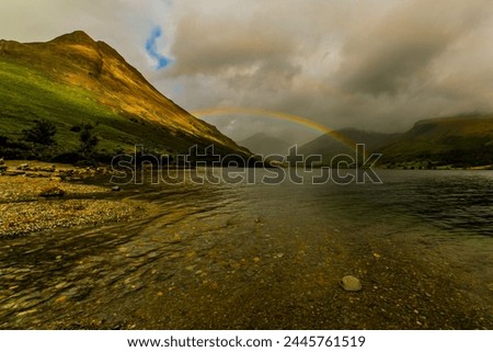 View towards distant Great Gable with rainbow across Wast Water with Yewbarrow on the left and the Scafell Range right, Wasdale, Lake District National Park, UNESCO World Heritage Site Royalty-Free Stock Photo #2445761519