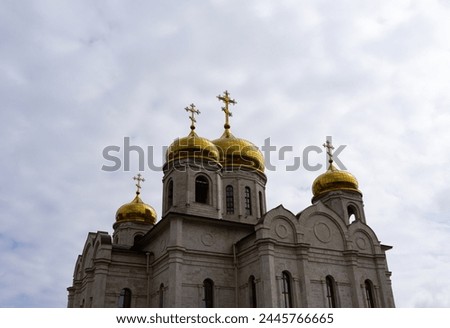 A contemporary orthodox gray stone church isolated against cloudy skies.