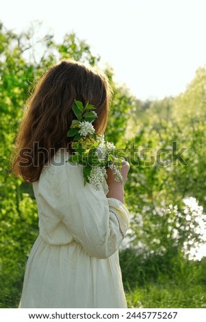 girl in rustic dress with bird cherry tree flower bouquet in garden, natural abstract background. concept of youth, romance, dreams, love. gentle lovely image. spring season