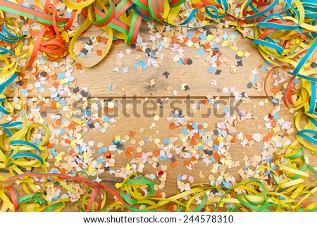 Confetti and steamer on wooden background