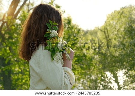 girl in rustic white dress with bird cherry tree flower bouquet outdoor, natural abstract background. concept of youth, romance, dreams, love. gentle lovely image. spring season