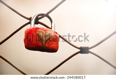 Grungy love padlock with heart decoration attached to the bridge in Paris. Valentine's day background. Toned photo.