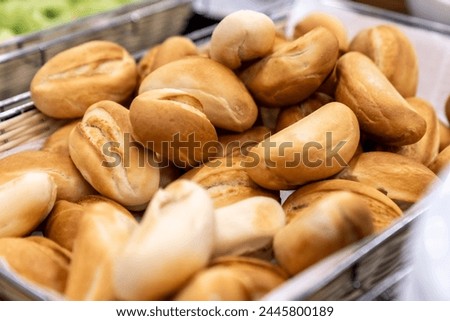 a basket filled with lots of different kinds a group of bread rolls. Mini bread baguettes in basket. Fresh bread background. heap of bread pieces to accompany food in a bakery, background