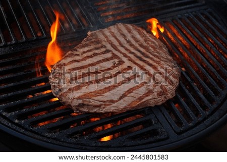 Traditional American barbecue flanksteak steak as close-up on a charcoal grill with fire Royalty-Free Stock Photo #2445801583