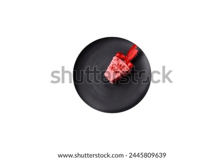 Delicious sweet cheesecake with fruits covered with icing with a wooden stick on a dark concrete background