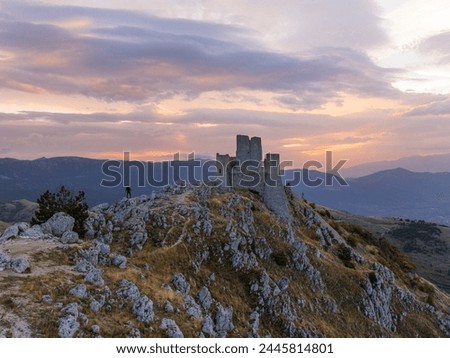 A person admires the Rocca Calascio castle during an autumn sunrise, National Park of Gran Sasso and Monti of Laga, Abruzzo, Italy, Europe Royalty-Free Stock Photo #2445814801
