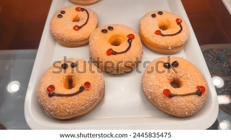 Display of delicious pastries in a bakery with assorted glazed donuts, Assorted fresh donuts on display racks at the donut shop. donuts sprinkled with chocolate meises on top, potato donuts isolated. 