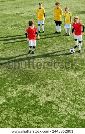 young boys stand triumphantly on top of a soccer field, exuding joy and camaraderie after a match. They are surrounded by the lush green grass and goalposts, showcasing their victory. Royalty-Free Stock Photo #2445852801