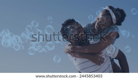 Image of bubbles over smiling african american couple. global sport and digital interface concept digitally generated image.