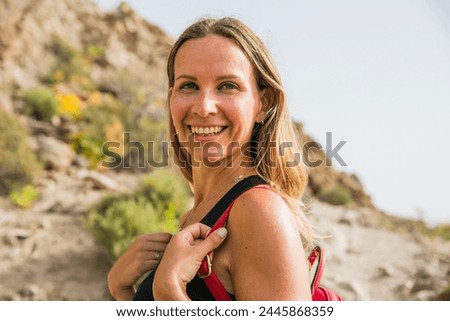 Portrait of an attractive woman smiling while hiking in nature.