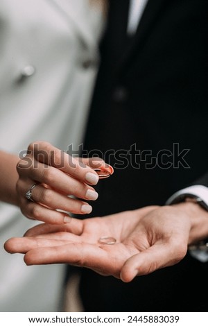 The hands are wearing suits and one hand has a wedding ring.