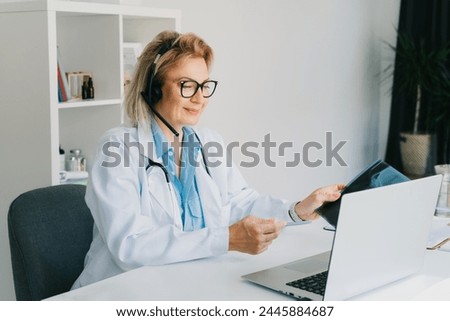 Female doctor in headset make online video call consult patient on laptop. Middle aged woman therapist videoconferencing for domestic health treatment. Telemedicine. Online remote medical appointment. Royalty-Free Stock Photo #2445884687