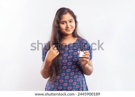 Young woman suffering from hair fall problems using hair serum product for hair treatment