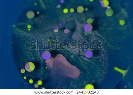 Blue background with colorful paint spheres, liquid texture