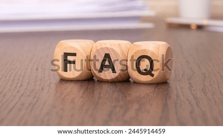 text 'FAQ - Frequency Asked Questions' on wooden cubes, brown background
