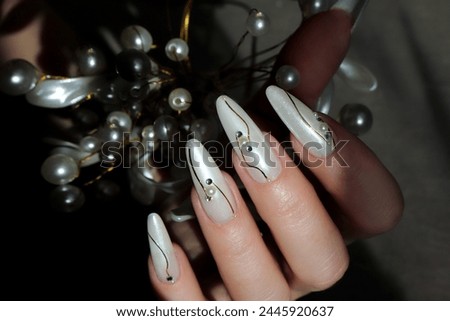 Pearl design with rhinestones on long extended nails. Royalty-Free Stock Photo #2445920637