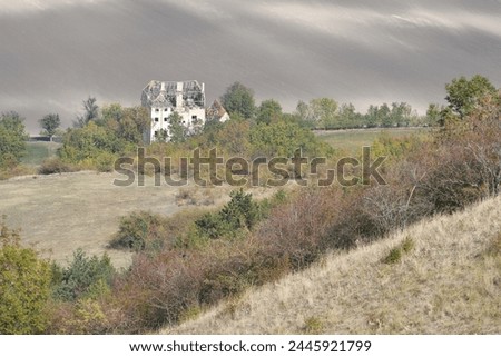 Ruin of a big house in inhospitable landscape, shadows and lights Royalty-Free Stock Photo #2445921799