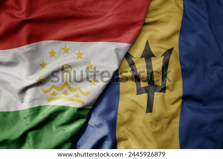 big waving national colorful flag of barbados and national flag of tajikistan. macro