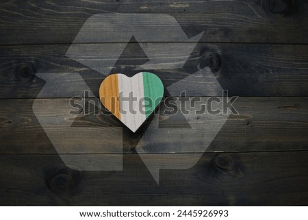 wooden heart with national flag of cote divoire near reduce, reuse and recycle sing on the wooden background. ecological concept