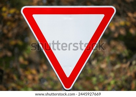 Give way road sign over blurred background, close-up photo