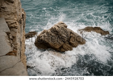 Waves Crashing Against Rocky Shoreline Royalty-Free Stock Photo #2445928703