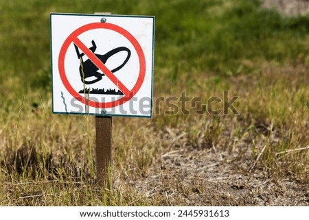 Do not walk on grass, park sign on small wooden pole mounted on the lawn