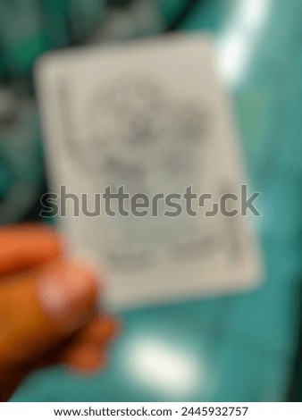 unfocused photo of joker card in hand