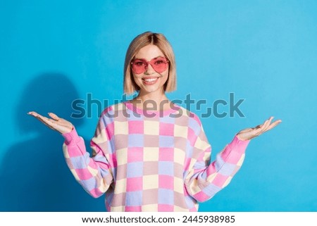 Photo portrait of pretty young girl sunglass celebrate party hands empty space wear trendy pink outfit isolated on blue color background